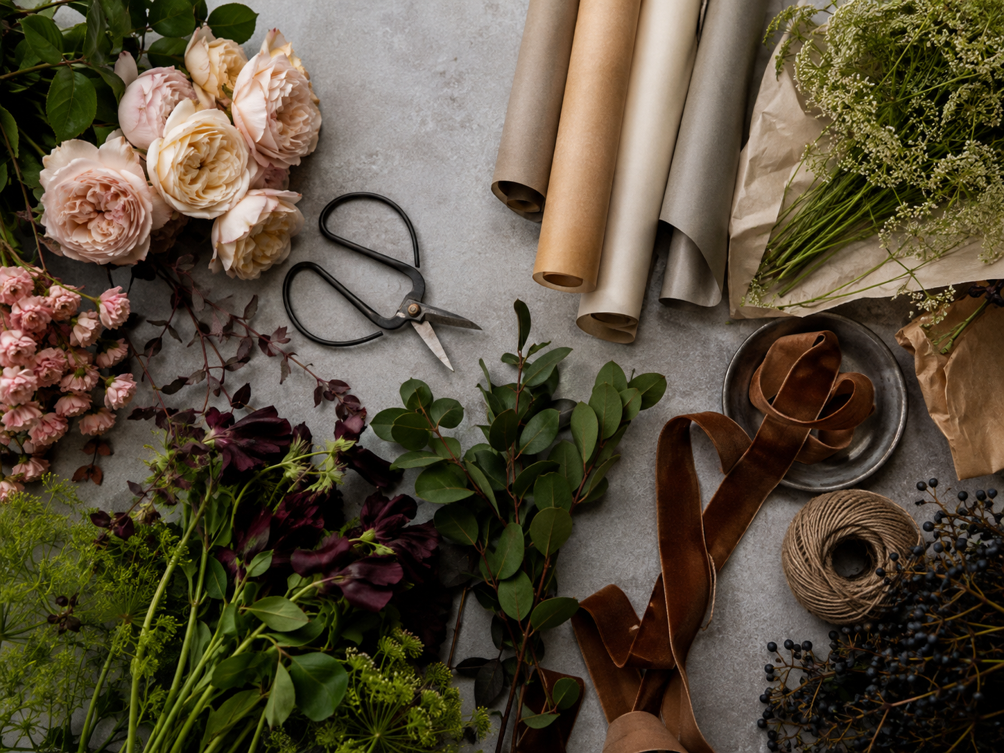 Flat lay of flowers, ribbon and florist tools